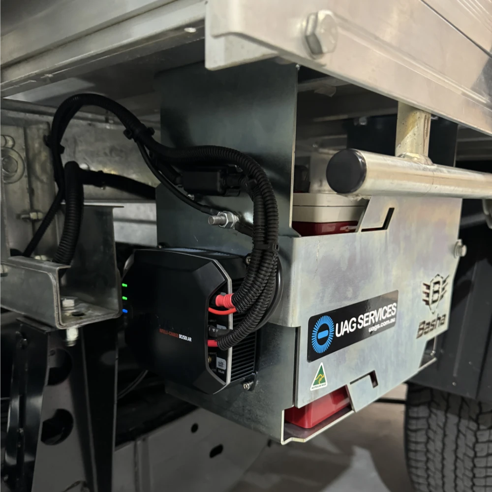 Close-up of a dual battery system with circuit breaker under a vehicle tray