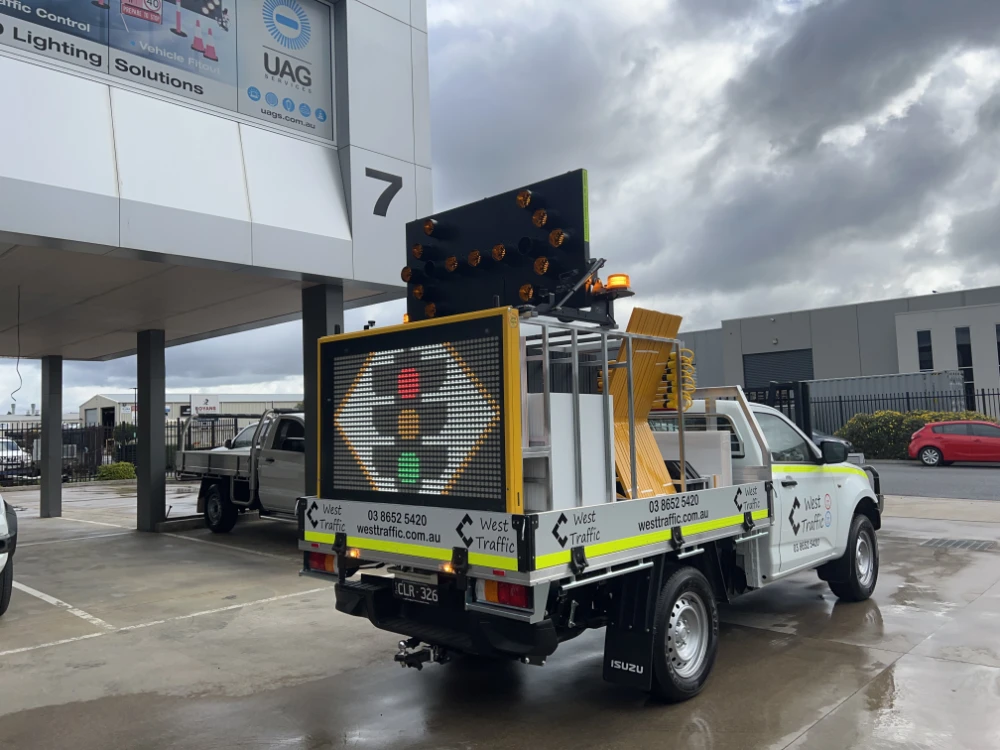 Traffic control vehicle with glowing arrow boards at a worksite
